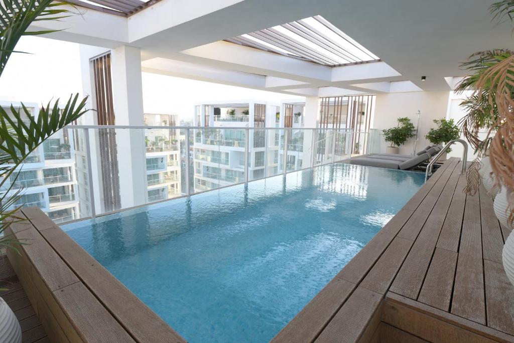 an indoor swimming pool with a view of a building at Omega Pent House in Eilat