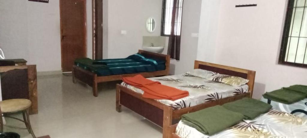 a room with two beds and a chair in it at Amrutha Easy Stay in Kalasa