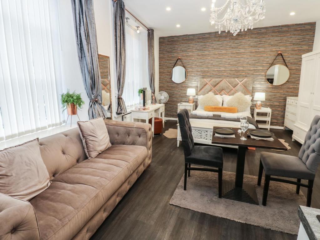 a living room with a couch and a table at The Railway Apartment in Hexham