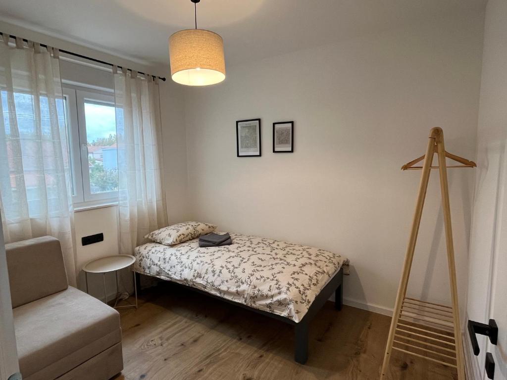a bedroom with a bed and a chair and a window at Marta Apartment in Čitluk