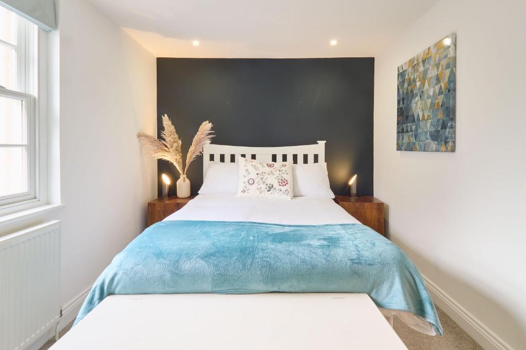 a bedroom with a white bed with a blue blanket at Host & Stay - Aurora in Deal