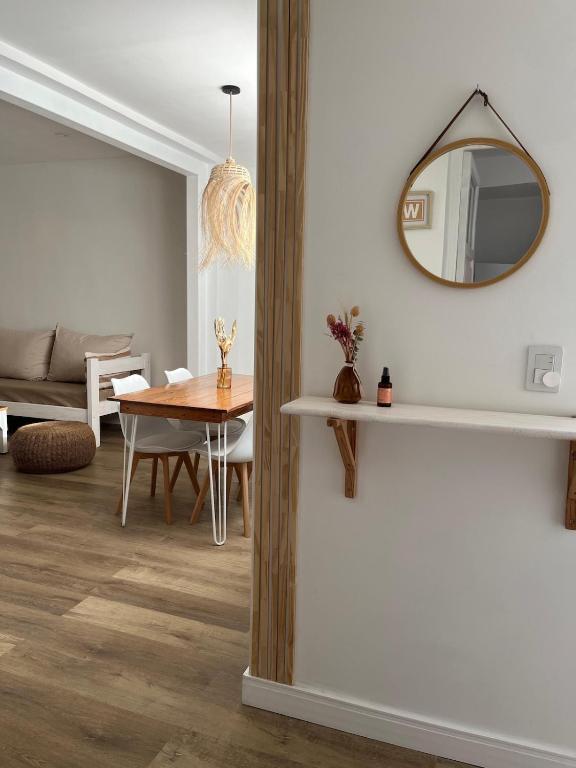 a living room with a table and a mirror at Andina Apart - Calm in the heart of Mendoza in Mendoza