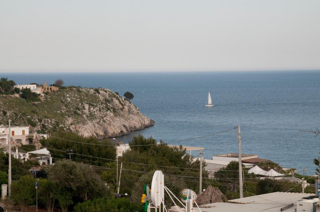 a sailboat in the ocean with a small boat at La Celestina in Castro di Lecce