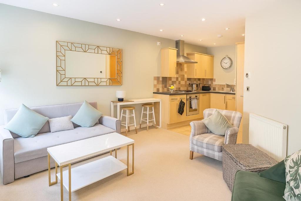 Una sala de estar con un sofá y una cocina. en Lady Peckett's Yard - Free Parking - Central Apt, en York