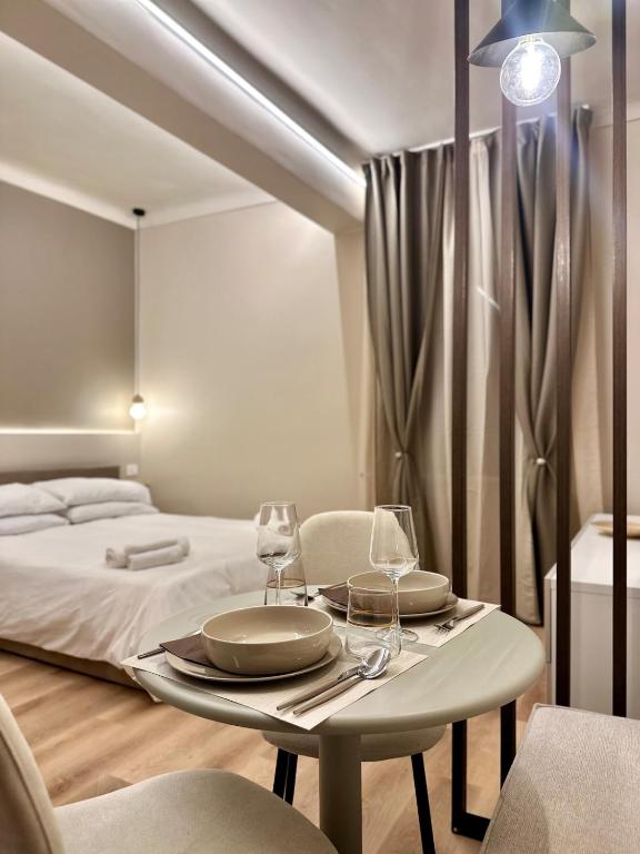 a room with a table with two glasses and a bed at La Pepita - nel cuore del centro in Turin