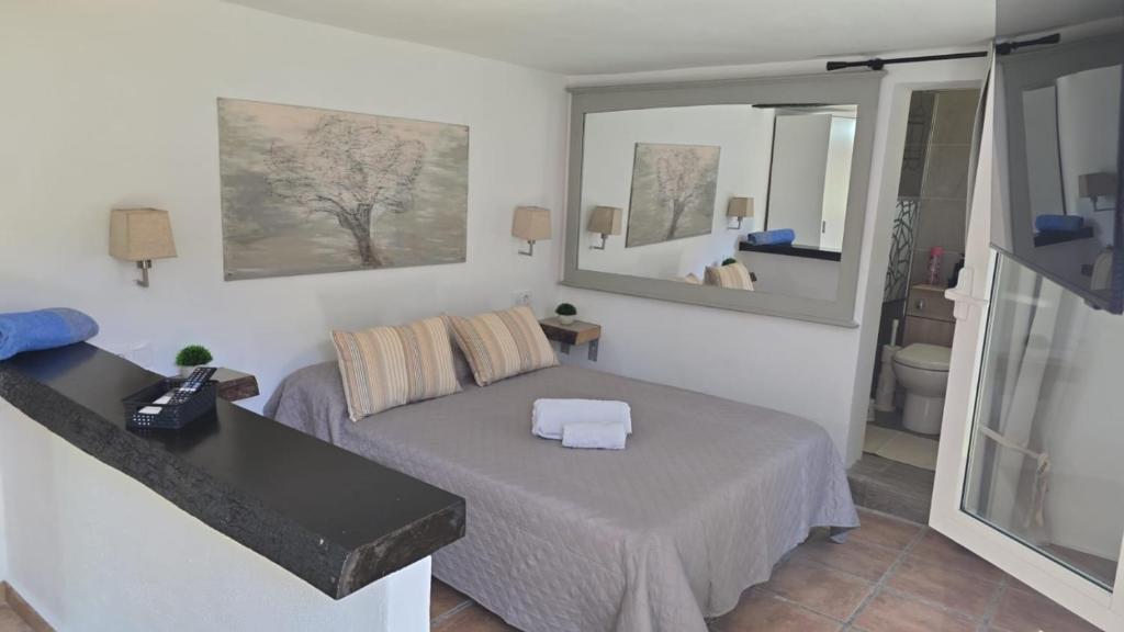 a living room with a bed and a mirror at Finca Feliciano in Novo Sancti Petri