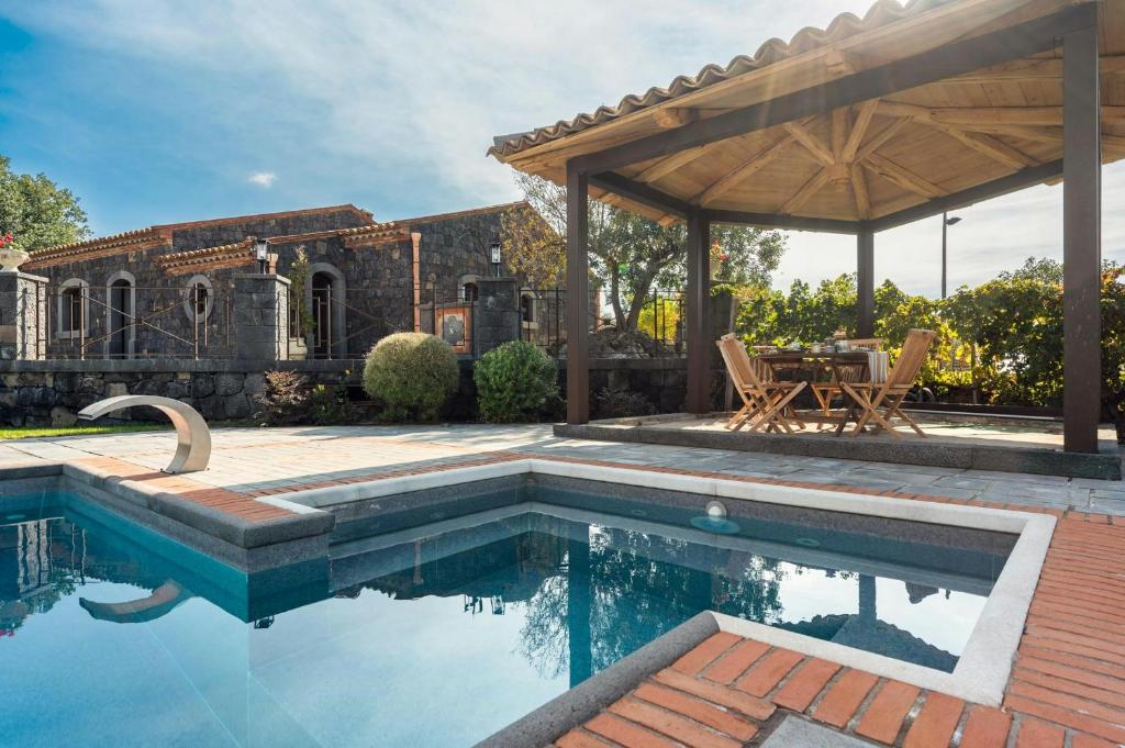 a swimming pool in a backyard with a pavilion at Villa With Pool And Vineyards Among Etna Vineyards in Santa Maria di Licodia