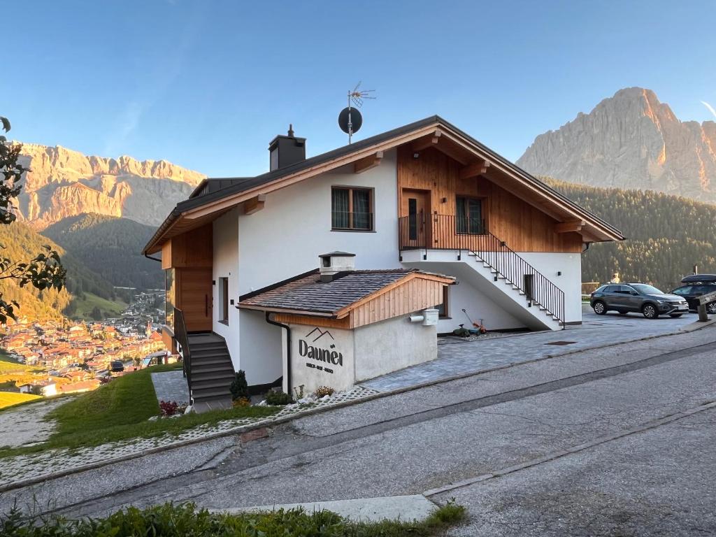 une maison sur le côté d'une route avec des montagnes dans l'établissement Daunëihof, à Selva di Val Gardena
