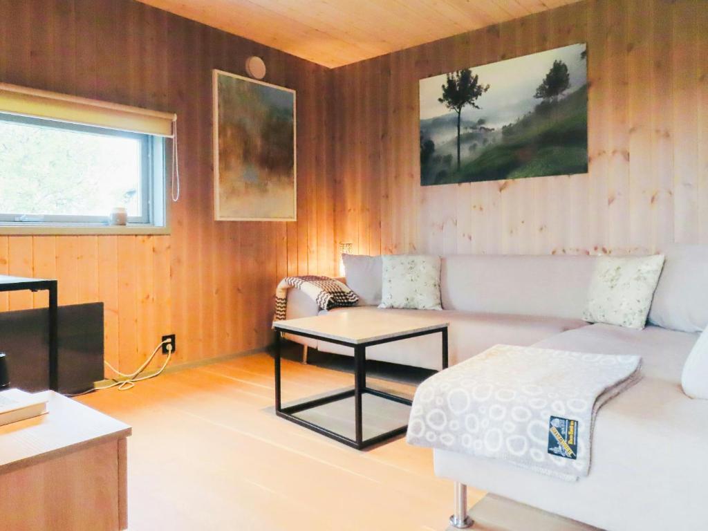een woonkamer met een bank en een tafel bij Modern Cabin With Panoramic Views In Nøsen in Lykkja