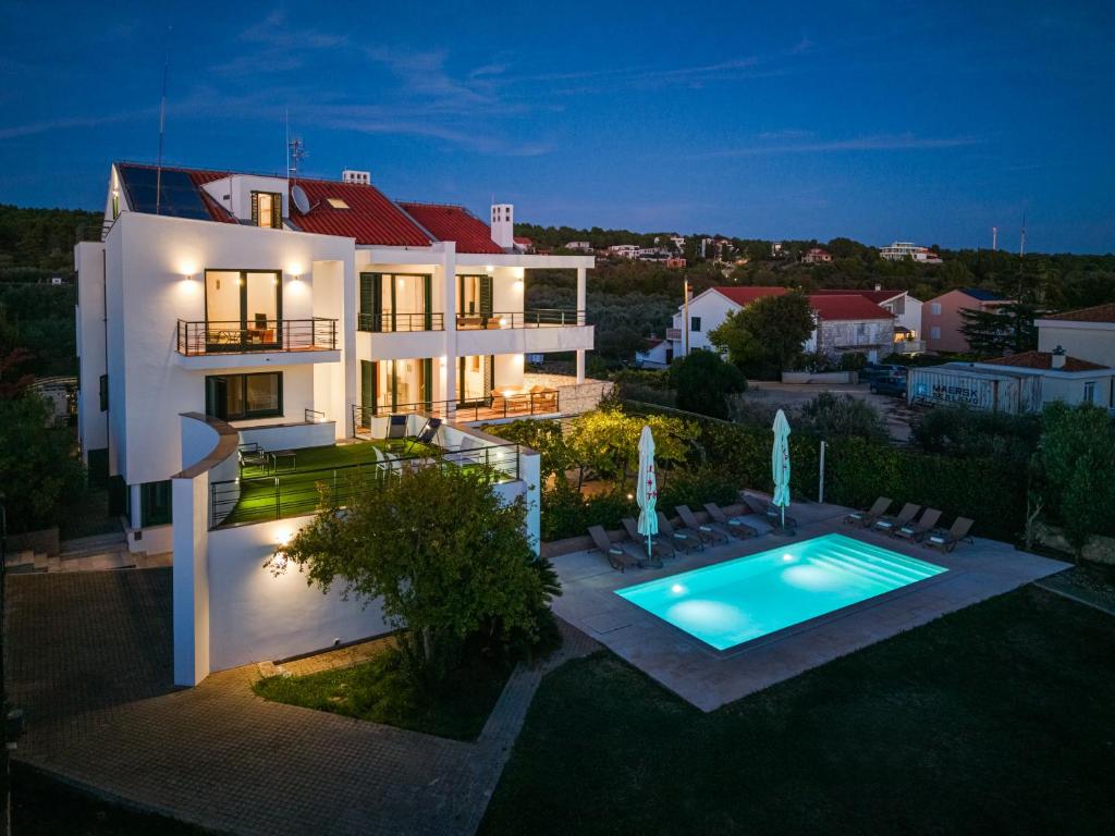 a house with a swimming pool in the backyard at Villa Paradise in Zadar with 6 bedrooms, pool and gaming room in Zadar