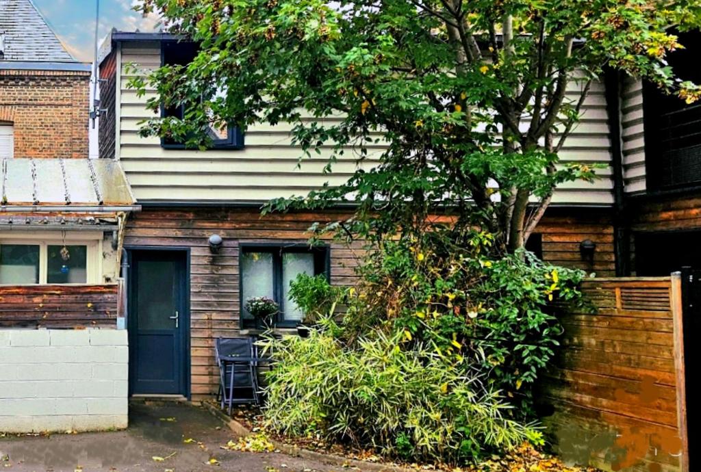 a house with a blue door and a tree at Maison Duplex Confort-Coté Cour et Jardins-Centre Gare in Amiens