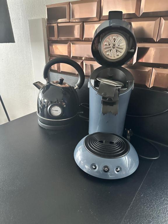 a tea kettle and a clock on top of a counter at woonboot de dobber loosdrechtse plassen 6-8 personen in Loosdrecht