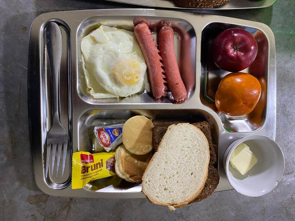 Una lonchera con salchichas, huevos, pan y otros alimentos. en Hostel DANEXAN APA, en Nukus