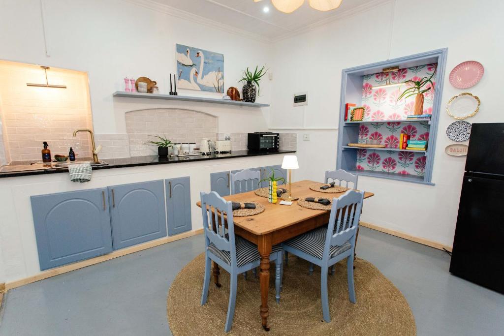 a kitchen with a wooden table and blue cabinets at 19 Mare St Apartments in Howick