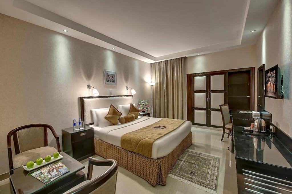 a hotel room with a bed and a desk at Palm Beach Hotel in Dubai