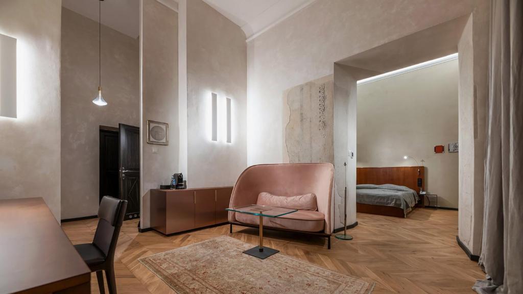 a living room with a chair and a bed at Hotel Pod Różą in Kraków
