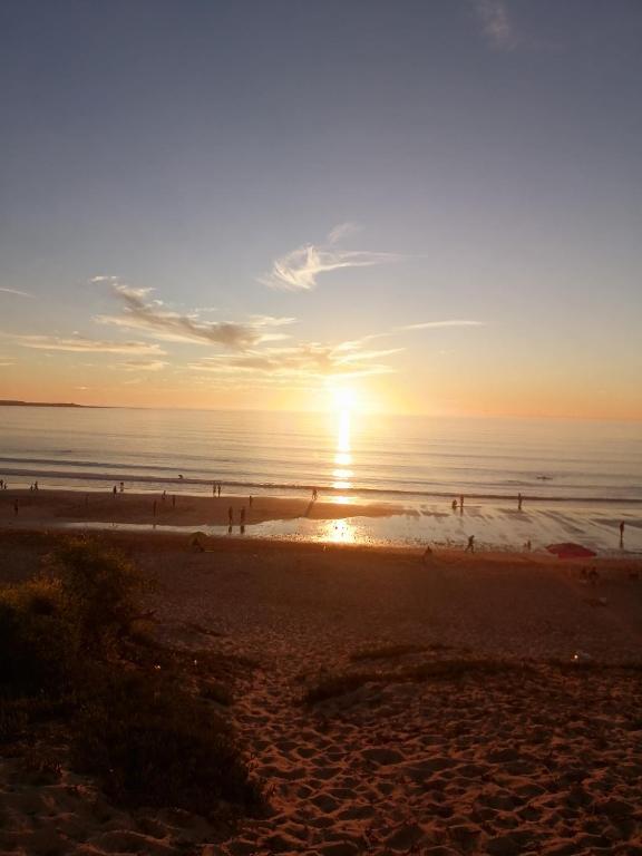 a group of people on the beach at sunset at Dar Sofiane in Sidi Bouzid