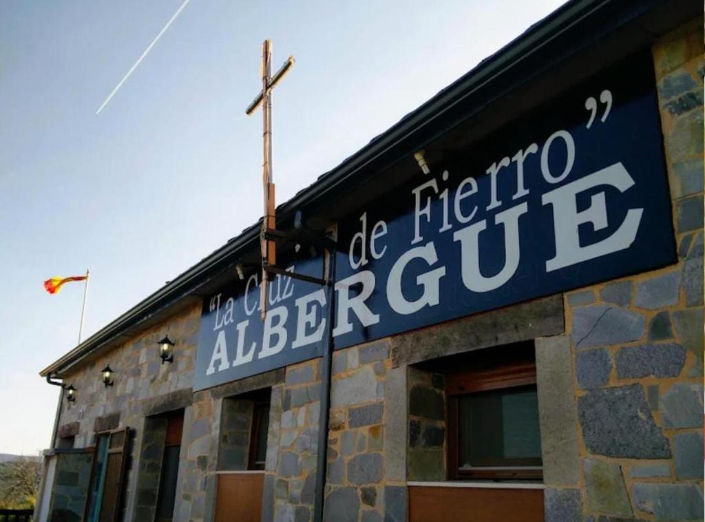 a sign on the side of a building at Albergue de peregrino Cruz de Fierro in Foncebadón