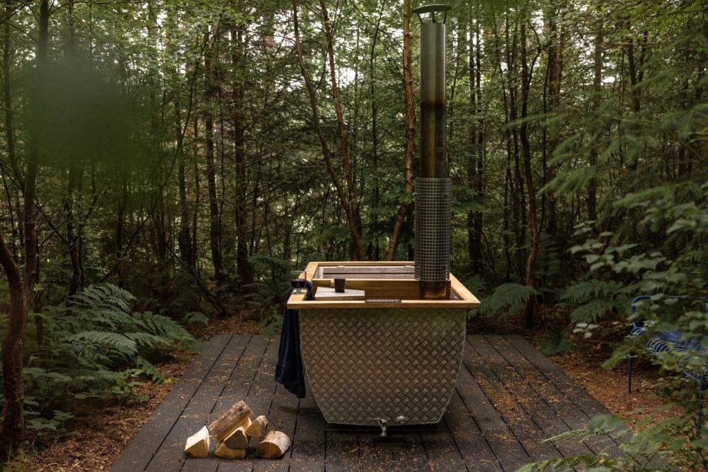 a grill in the middle of a forest at Burnside Cottage By Birch Stays in Stonehaven