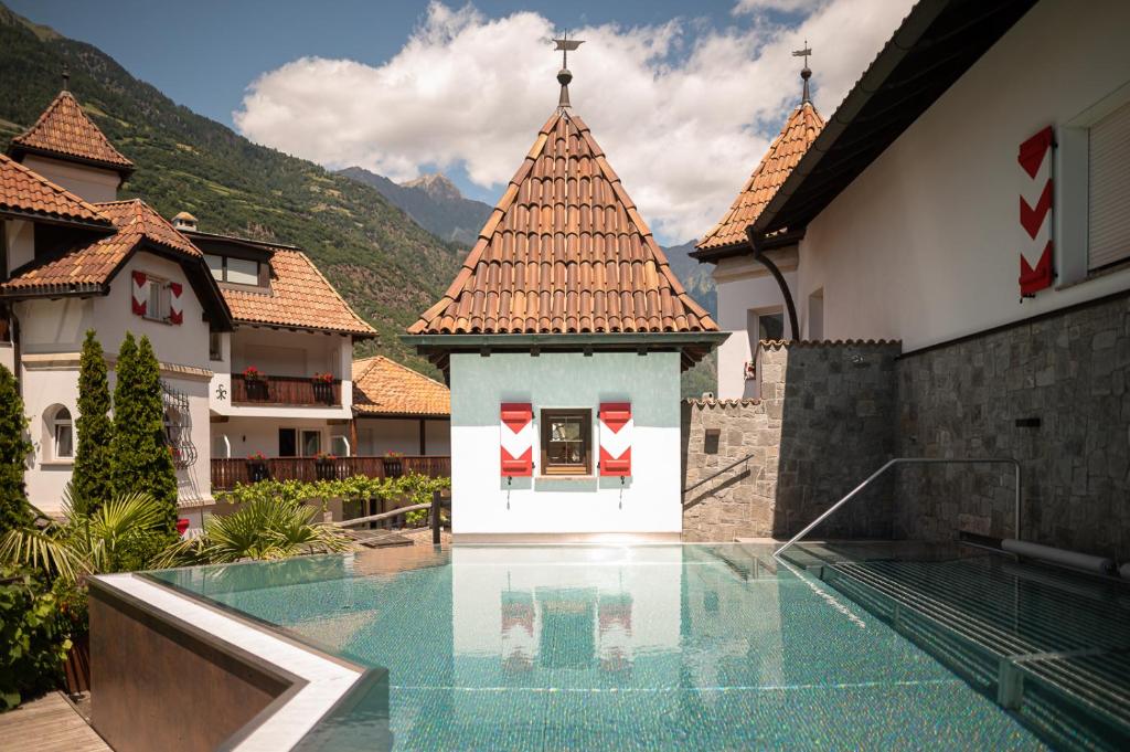 a swimming pool in a house with a mountain at Vitalpina Hotel Schulerhof in Plaus