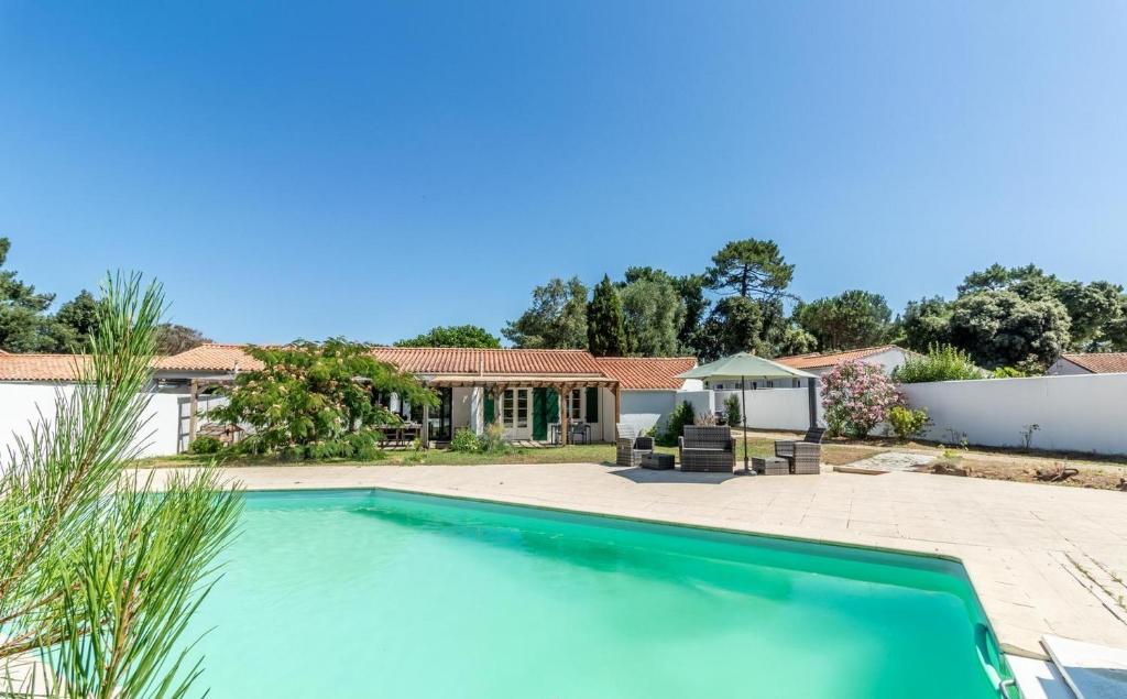 a swimming pool in front of a house at Gîte des pins in Sainte-Marie-de-Ré