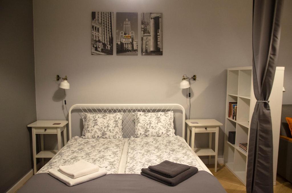 1 dormitorio con 1 cama blanca y 2 mesitas de noche en Studio Panorama "Night and Day" en Varsovia