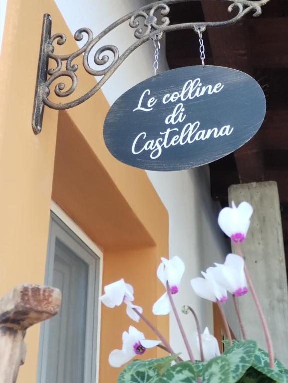 a sign for a restaurant with white flowers in a vase at Le Colline di Castellana in Cerratina
