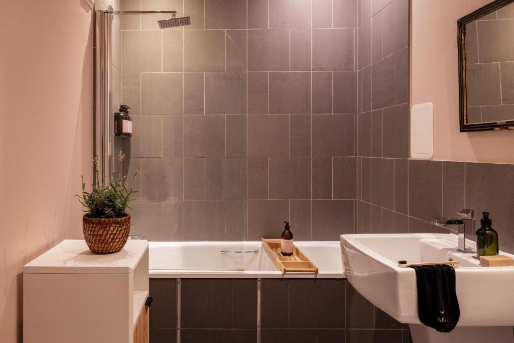 a bathroom with a white tub and a sink at Fernshade Cottage By Birch Stays in Stonehaven