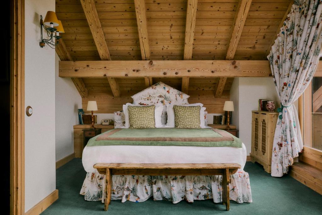 a bedroom with a bed with a wooden ceiling at Hôtel Saint-Georges in Megève