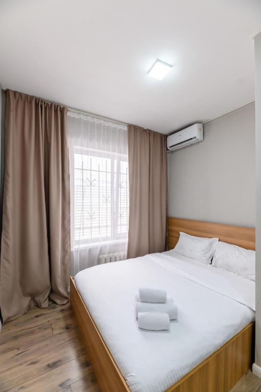 a bedroom with a large bed with two towels on it at Uide hotel in Almaty