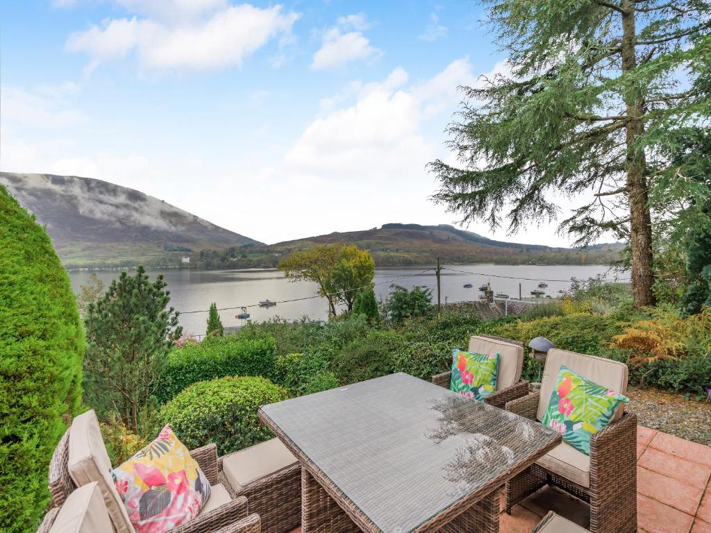 a table and chairs with a view of a lake at Lochside View in Lochearnhead