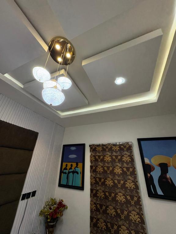 a living room with a ceiling fan and paintings at Hog Inn Hotel in Benin City