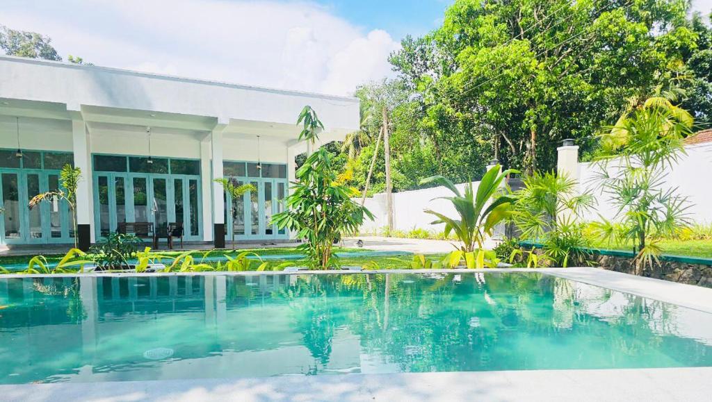 a swimming pool in front of a house at STARK Villa in Talpe