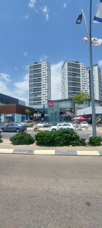 a street with cars parked in a parking lot with tall buildings at K Home 2 in Ma'ale Gamla