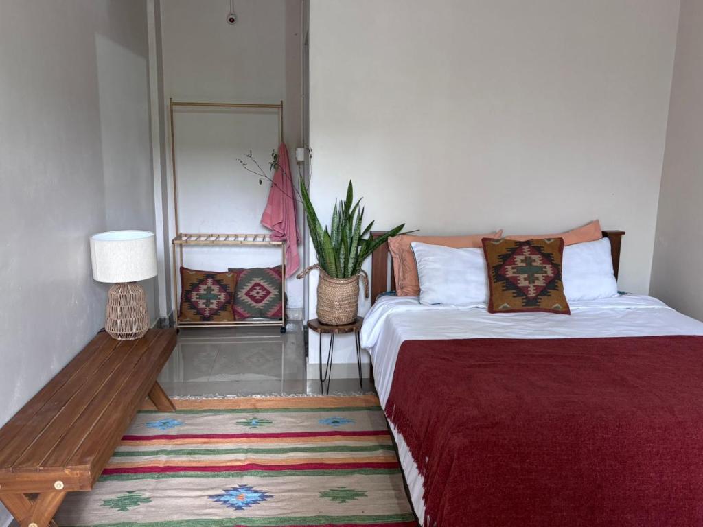 ein Schlafzimmer mit 2 Betten, einem Tisch und einer Pflanze in der Unterkunft Drifters Surf Eat Stay in Kappil