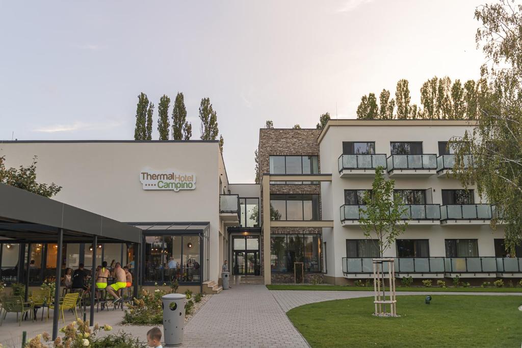 a building with people sitting outside of it at Thermal Hotel Campino in Dunajská Streda