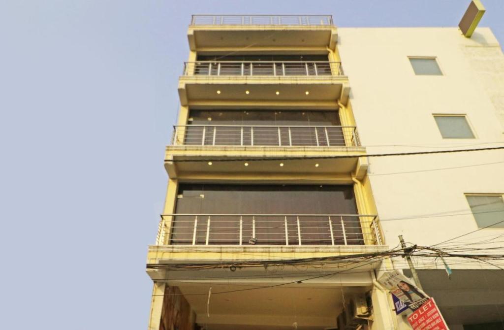 a tall building with a balcony and a building at Hotel Blist villa in New Delhi