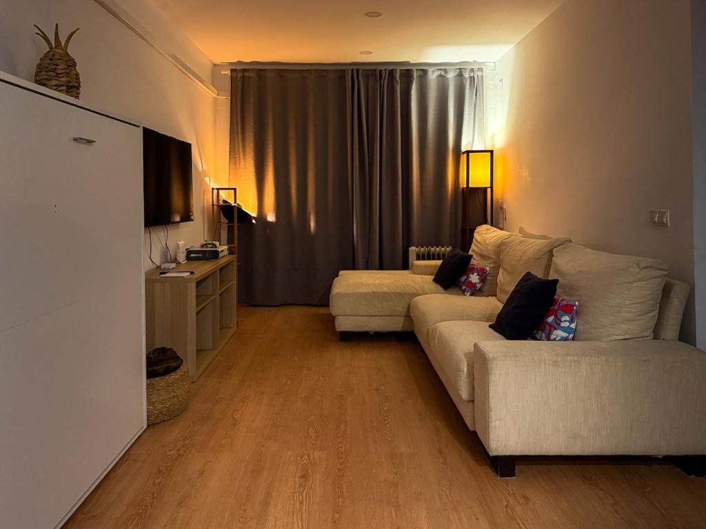a living room with a white couch and a tv at Apartment in 5 Mares development in Puebla de Farnals