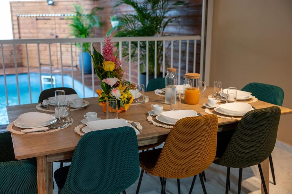 ein Esstisch mit Stühlen und ein Tisch mit einem Billardtisch in der Unterkunft Villa JOLIS 4 chambres avec piscine en Guadeloupe in Les Abymes