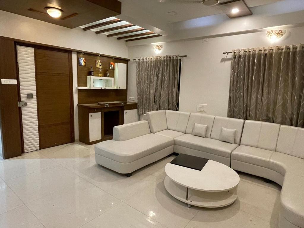 ein Wohnzimmer mit Sofa und Tisch in der Unterkunft 4 BHK Duplex Flat at Baner, Pune in Pune