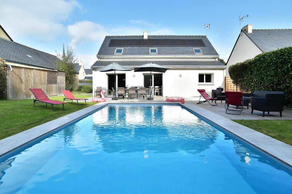 Le Vau PiardにあるLes 9 plages - Piscine privéeの赤い椅子が置かれた家の庭にあるプール