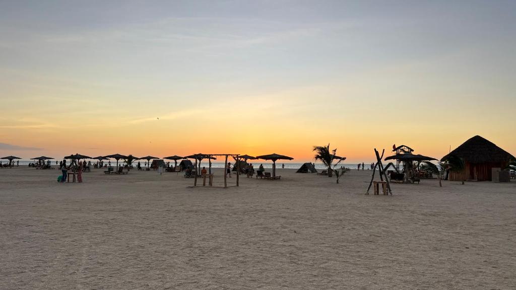 - un groupe de parasols sur une plage au coucher du soleil dans l'établissement Hotel Wayira Beach by On vacation, à Ríohacha