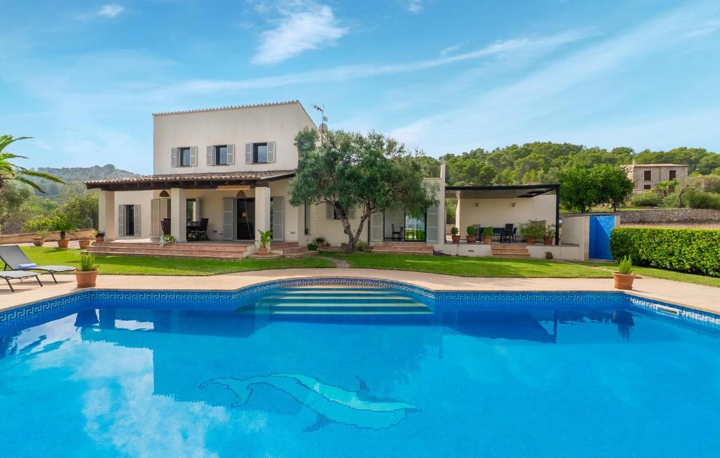 a villa with a swimming pool in front of a house at S'ametllerar in Artá
