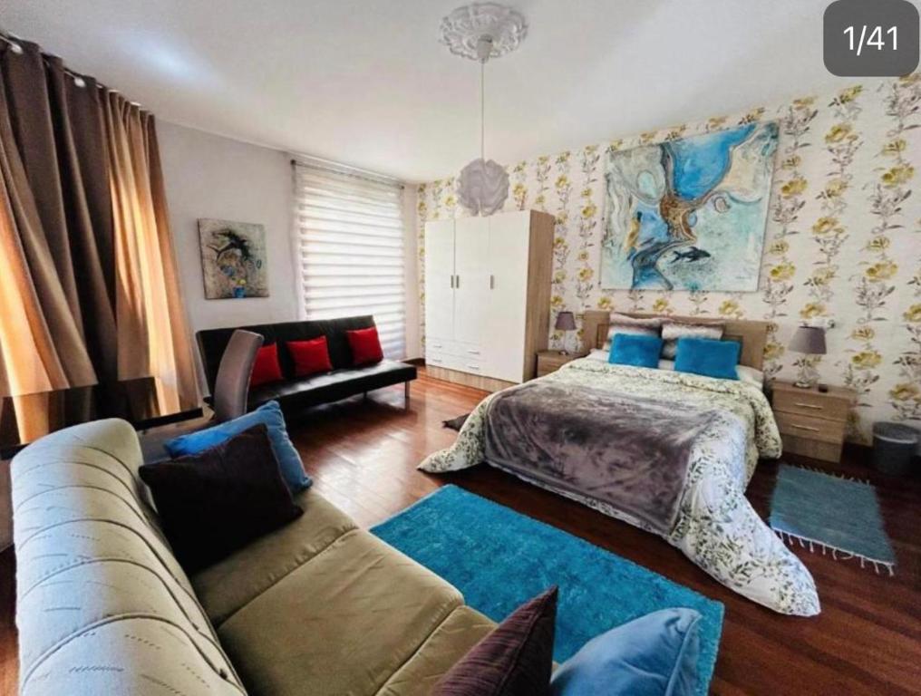 een slaapkamer met een bed en een bank bij Arquitecto de la Vida - Plaza Mayor in León