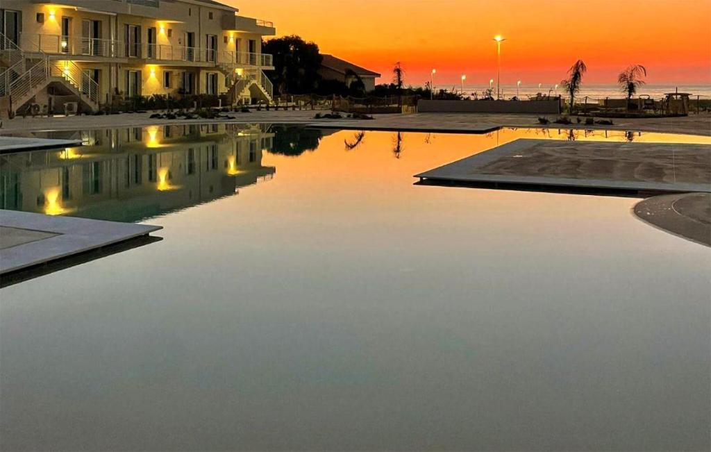 マルツァメミにある1 Bedroom Awesome Apartment In Marzamemiの夕日を背景に水のプール