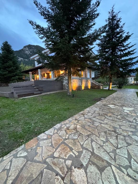 a house with a tree and a stone walkway at eleni's villa in Kandhíla