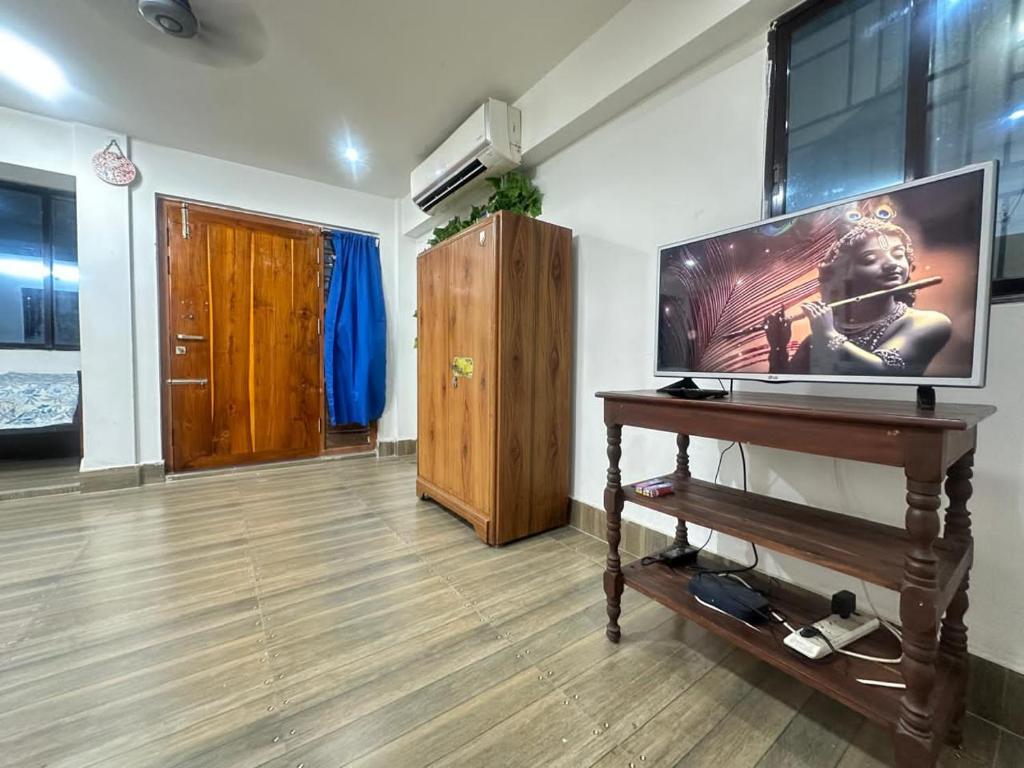een woonkamer met een grote flatscreen-tv bij City Nest Studio in Agartala