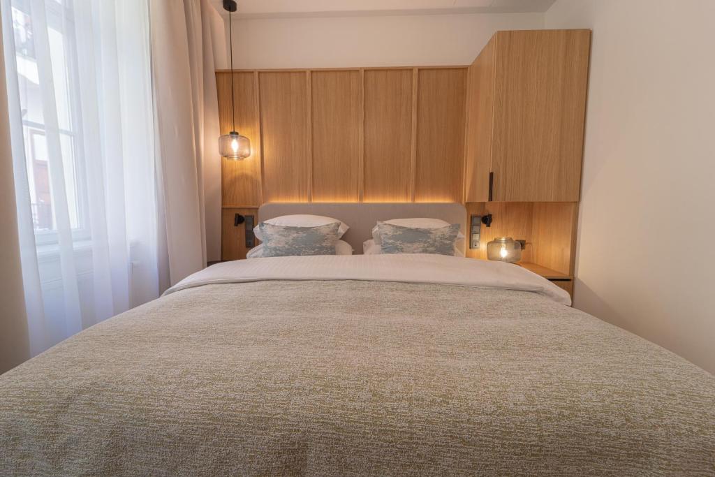 a bedroom with a large bed with two pillows at Six Residences Prague in Prague