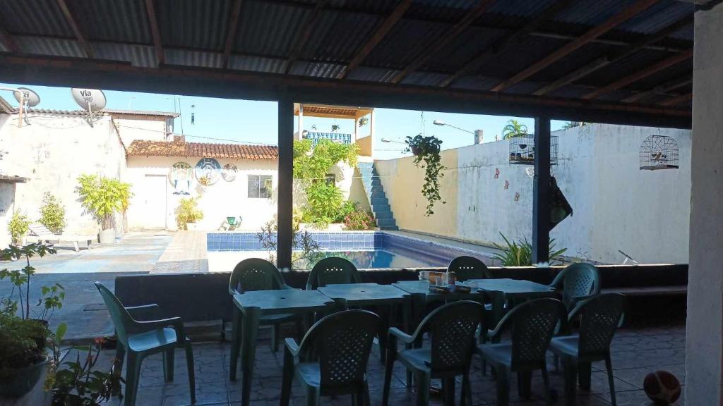 a restaurant with tables and chairs and a pool at Cunhas II Áreas COP30 Moskeiro Belém in Belém