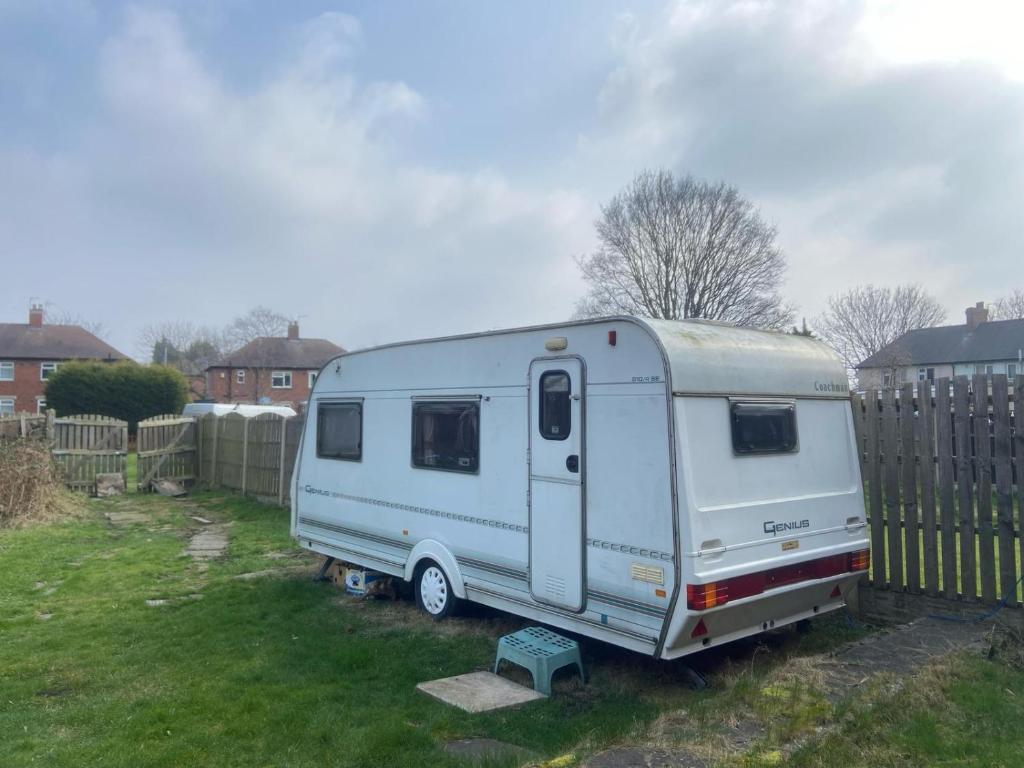a white trailer parked in a yard next to a fence at Комната in Wakefield